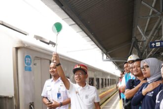 Menggunakan topi masinis, General Manager PLN Unit Induk Distribusi Jakarta, Lasiran melepas kereta api para peserta Mudik Asyik Bersama BUMN 2024 di Stasiun Pasar Senen (5/4).