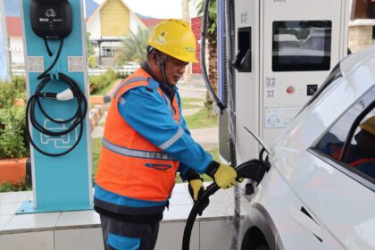 Petugas PLN membantu pengguna kendaraan listrik melakukan pengisian daya di SPKLU Rest Area Jalan Tol Trans Sumatera KM 20B. Foto: Dok PLN