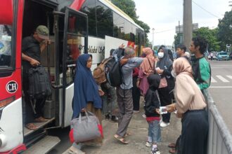 Suasana arus balik kedatangan bus Antar Kota Antar Provinsi (AKAP) yang membawa para pemudik tiba di Terminal Kampung Rambutan, Jakarta Timur, pada Minggu (14/4) siang. Foto: Joesvicar Iqbal/ipol.id