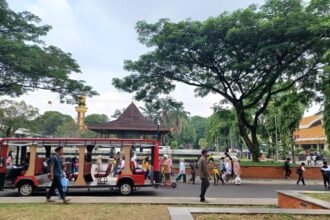 Para pengunjung Taman Mini Indonesia Indah (TMII) berwisata menggunakan kendaraan listrik pada libur Lebaran Idul Fitri 1445 Hijriah menikmati objek pemandangan dan udara segar di ruang terbuka hijau. Foto: Joesvicar Iqbal/ipol.id
