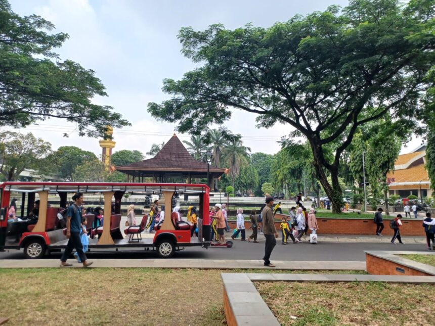 Para pengunjung Taman Mini Indonesia Indah (TMII) berwisata menggunakan kendaraan listrik pada libur Lebaran Idul Fitri 1445 Hijriah menikmati objek pemandangan dan udara segar di ruang terbuka hijau. Foto: Joesvicar Iqbal/ipol.id