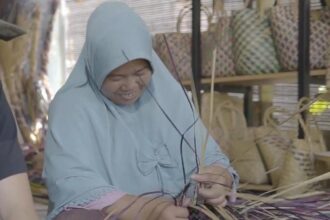 Di tangan nasabah PT Permodalan Nasional Madani (PNM) dari Banjarmasin, rumput purun disulap menjadi berbagai macam produk fungsional, salah satunya jadi tas cantik. Dia adalah nasabah PNM Unit Cempaka Banjarmasin bernama Salasiah. (PNM)