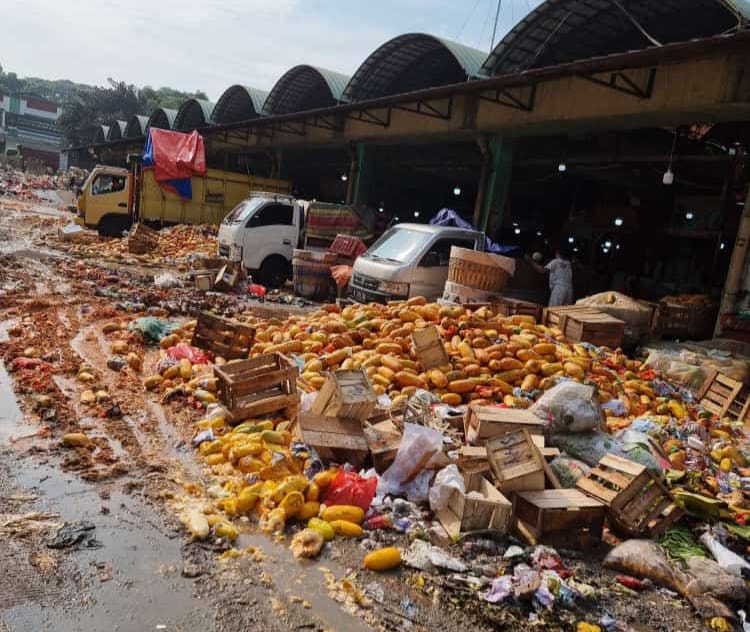 Para pedagang di Pasar Induk Kramat Jati, Kecamatan Kramat Jati, Jakarta Timur, terpaksa membuang puluhan ton pepaya dagangannya karena sepi pembeli dan harga anjlok pada Senin (22/4). Foto: Joesvicar Iqbal/ipol.id