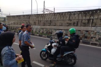 Petugas Lapas Kelas I Cipinang, Jatinegara, Jakarta Timur, saat membagikan paket takjil kepada warga di Jalan Bekasi Timur Raya pada Senin (1/4) sore. Foto: Joesvicar Iqbal/ipol.id