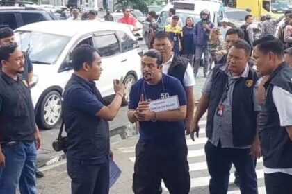 Gathan (mengenakan baju tahanan) mengikuti proses 17 adegan rekonstruksi diperagakan sejak turun dari kendaraan, menghampiri, terlibat cekcok dengan korban, melakukan penembakan di perkantoran di Jatinegara, Jakarta Timur, hingga membuang senjata di Sungai Ciliwung, Kamis (4/4). Foto: Ist