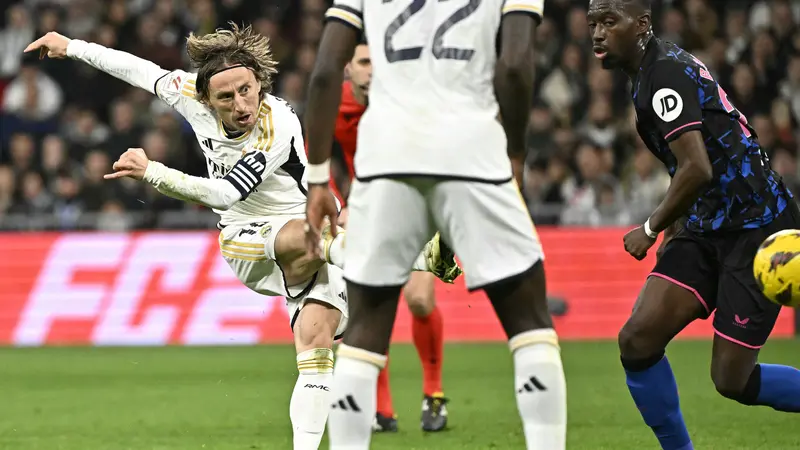 Pemain Real Madrid, Luka Modric mencetak gol ke gawang Sevilla dari luar kotak penalti pada laga lanjutan Liga Spanyol 2023/2024 di Stadion Santiago Bernabeu, Madrid, Spanyol, Senin (26/02/2024) dini hari WIB. (AFP/Javier Soriano)