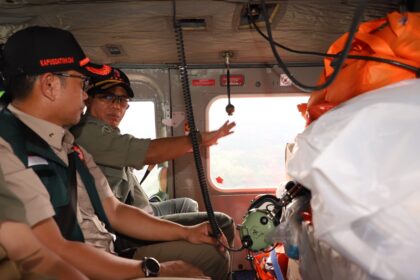 Kepala Badan Nasional Penanggulangan Bencana (BNPB) Letjen TNI Suharyanto (kanan tengah kemeja hijau) didampingi Kepala Pusat Data Informasi dan Komunikasi Kebencanaan BNPB, Abdul Muhari saat melakukan peninjauan udara dengan helikopter sekaligus membawa bantuan logistik untuk penanganan darurat banjir dan tanah longsor di Kabupaten Luwu, Sulawesi Selatan, Selasa (7/5). Foto: humas