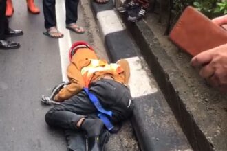 Kondisi seorang pekerja tergeletak di aspal Jalan Raya HR Rasuna Said, Kuningan, Setiabudi, Jakarta Selatan, usai terjatuh dari ketinggian Stasiun LRT Kuningan, pada Jumat (10/5). Foto: Tangkapan layar dalam video yang beredar di media sosial