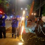 Suasana sejumlah petugas melakukan pengerjaan mengatasi jaringan utilitas pada pembangunan crossing saluran air di Jalan Raya Bogor, Ciracas, Jakarta Timur, pada Senin (27/5) malam. Foto: Ist
