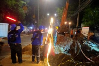 Suasana sejumlah petugas melakukan pengerjaan mengatasi jaringan utilitas pada pembangunan crossing saluran air di Jalan Raya Bogor, Ciracas, Jakarta Timur, pada Senin (27/5) malam. Foto: Ist