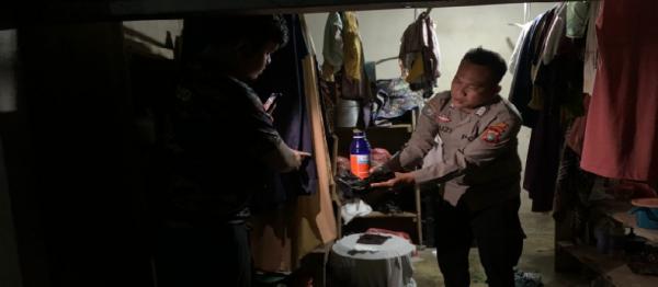 Anggota polisi memegang botol racun yang diduga diminum korban. (Foto : Ist)