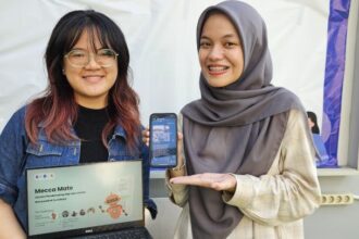 Hanny (kiri) dan Fathia Rahmanisa saat menunjukkan tampilan dari platform Mecca Mate rancangan timnya dari Departemen Sistem Informasi ITS. Foto: ITS