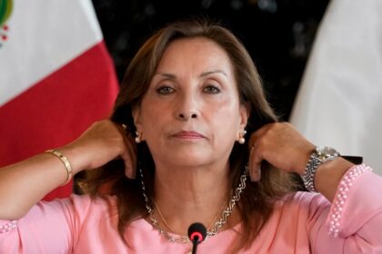 Presiden Peru Dina Boluarte menunjukkan perhiasan yang ia kenakan dalam konefrensi pers di Istana Pemerintahan di Lima, Peru, pada 5 April 2024. (Foto: AP/Martin Mejia)
