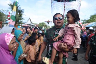 Kepala Staf Angkatan Darat (Kasad) Jenderal TNI Maruli Simanjuntak menggendong seorang anak saat menyambangi warga Desa Karengrejo, Kecamatan Karang Bintang Kabupaten Tanah Bumbu, Kalimantan Selatan, Jumat (7/6/2024). Foto: Dispenad