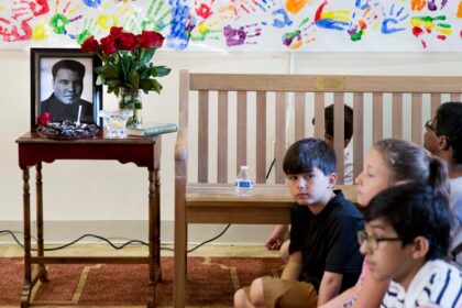 Anak-anak duduk di samping foto Muhammad Ali yang dipajang selama acar doa bersama di Louisville, Kentucky pada 5 Juni 2016 Foto: AP
