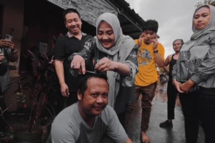 Caleg Partai Demokrat dapil 2 Kota Cirebon, Jawa Barat, Dian Novitasari saat mencukur rambut pendukungnya pasca PSU.(foto dok pribadi