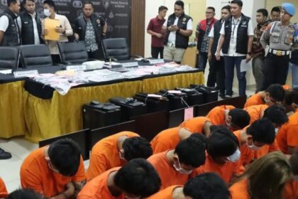 Sebanyak 29 orang pelaku sindikat judi online jaringan Jakarta Barat terhubung Kamboja tertunduk malu usai dibekuk jajaran Polres Metro Jakarta Barat, pada Jumat (12/8/2024). Foto: Polrestro Jakbar