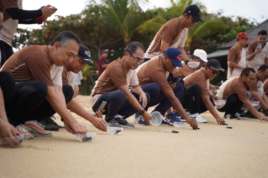 Direktur Group Business Development Telkom Indonesia, Honesti Basyir (ketiga dari kiri) dan Direktur Utama Finnet, Rakhmad Tunggal Afifuddin (ketiga dari kanan, topi hitam) saat melakukan pelepasan tukik di pantai Nusa Dua, Bali beberapa waktu lalu. Foto: Telkom Indonesia