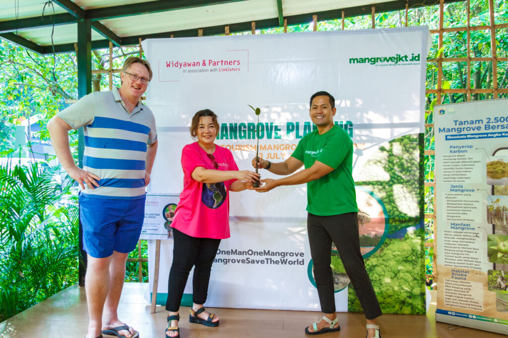 Simbolis penyerahan bibit mangrove oleh perwakilan Widyawan & Partners, Yolanda Hutapea kepada Founder Komunitas Mangrove Jakarta, Paundra Hanutama. (Alidrian Fahwi/ipol.id)