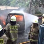 Sejumlah petugas Damkar memadamkan kobaran api yang membesar pada satu unit minibus yang membawa lima jerigen berisi Bahan Bakar Minyak (BBM) di tepi Jalan DI Panjaitan, Jatinegara, Jakarta Timur, Rabu (24/7/2024) siang. Foto: Joesvicar Iqbal/ipol.id