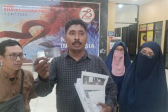 Pengacara korban, Muhammad Tasrif Tuasamu menunjukkan data para korban penipuan disalahgunakan pelaku R untuk membuat ATM, kredit dan pinjaman online di Mapolres Metro Jakarta Timur, Selasa (16/7/2024). Foto: Joesvicar Iqbal/ipol.id