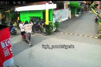 Pemuda tiba-tiba menyerang pengendara motor di Bekasi terekam kamera CCTV. (Foto tangkapan layar).