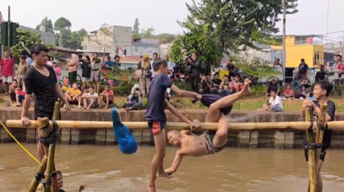 Suasana seru dua peserta lomba saling gebuk bantal dalam acara lomba bertajuk Semarak Kalimalang Hari Ulang Tahun (HUT) ke-79 RI di aliran Kalimalang di RW 04, Kelurahan Cipinang Melayu, Kecamatan Makasar, Jakarta Timur, pada Sabtu (24/8/2024). Foto: Joesvicar Iqbal/ipol.id