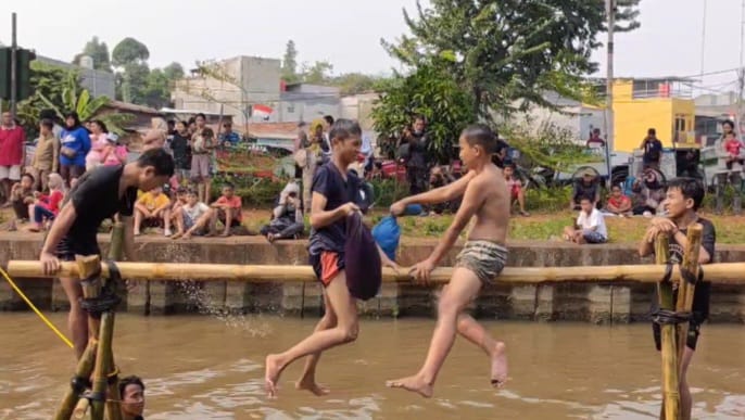 Suasana seru dua peserta lomba saling gebuk bantal dalam acara lomba bertajuk Semarak Kalimalang Hari Ulang Tahun (HUT) ke-79 RI di aliran Kalimalang di RW 04, Kelurahan Cipinang Melayu, Kecamatan Makasar, Jakarta Timur, pada Sabtu (24/8/2024). Foto: Joesvicar Iqbal/ipol.id