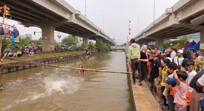 Suasana riuh penonton saat menyaksikan peserta lomba titian bambu tercebur di aliran Kalimalang dalam lomba diadakan warga RW 04, Cipinang Melayu, Makasar, Jakarta Timur, pada Sabtu (24/8/2024) siang-sore. Foto: Joesvicar Iqbal/ipol.id