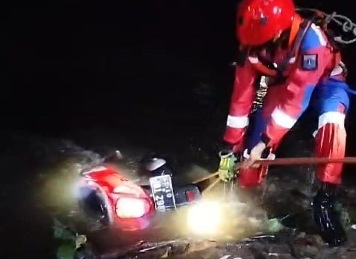 Sejumlah petugas Damkar melakukan evakuasi motor matic yang tercebur di aliran Kali Cipinang di Jalan Kramat Kedondong, Ciracas, Jakarta Timur, Sabtu (3/8/2024) sekitar pukul 20.30 WIB. Foto: Ist