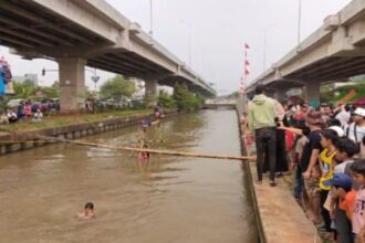 Suasana riuh penonton menyaksikan peserta lomba titian bambu tercebur di aliran Kalimalang dalam lomba diadakan warga RW 04, Cipinang Melayu, Makasar, Jakarta Timur, pada Sabtu (24/8/2024) siang-sore. Foto: Joesvicar Iqbal/ipol.id