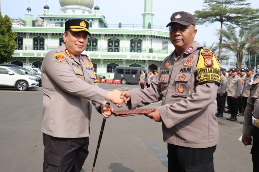 Kapolres Metro Jakarta Selatan, Kombes Pol Ade Rahmat Idnal (kiri) saat memberikan penghargaan kepada Bhabinkamtibmas Kelurahan Tegal Parang, Polsek Mampang Prapatan, Aiptu Adyi Wibowo (kanan) di halaman Mapolres Metro Jakarta Selatan, Selasa (10/9/2024). Foto: Ist