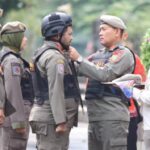 Kepala Satpol PP DKI Jakarta, Arifin memasangkan helm pada tim URC motor dalam pengamanan KTT Asean di Jakarta. Foto: Ist