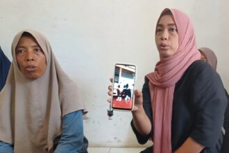 Yani, 46, (kiri) dan Suryati, 36, (kanan) menunjukkan foto Ibunda tercinta semasa hidup Nimih, 63, di kediaman di wilayah RT 03 RW 05, Kelurahan Bambu Apus, Kecamatan Cipayung, Jakarta Timur, Selasa (17/9/2024) siang. Foto: Joesvicar Iqbal/ipol.id