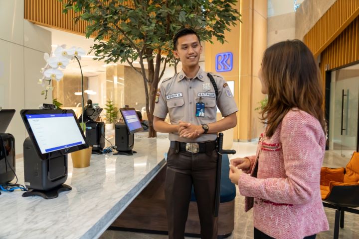 Seorang petugas security saat memberikan pelayanan kepada nasabah BRI. Foto: Dok BRI