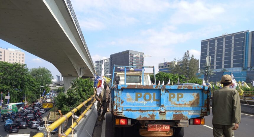 Satuan Polisi Pamong Praja (Satpol PP) Jakarta Timur melakukan penertiban dan atau pencopotan sejumlah atribut bendera partai di Jalan MT Haryono, Cawang, Kramat Jati, pada Rabu (11/9/2024) siang. Foto: Ist