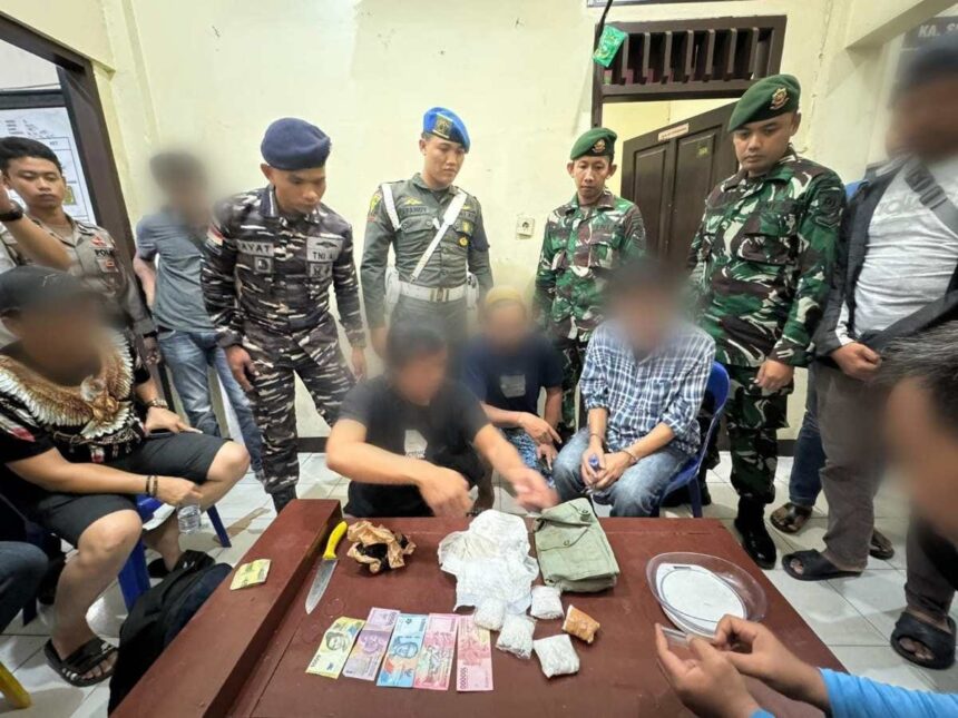 Satgas Yonarmed 11 Kostrad dan Tim Gabungan saat mengamankan dua pelaku penyelundupan 553 gram narkoba jenis sabu. Foto: Pen Satgas Yonarmed 11 Kostrad