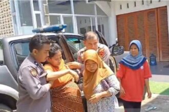 Anggota Polsek Parung membantu seorang ibu yang nyaris melahirkan di jalan, Parung. Foto: Humas Polres Bogor