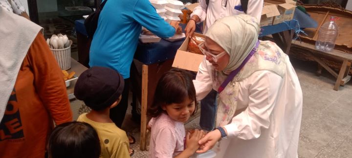 Wakil Ketua DPRD DKI Jakarta, Rani Mauliani saat membagikan makanan gratis roti dan susu untuk anak-anak di posko MSC.(Foto sofian/ipol.id)