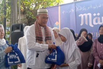 Anggota DPRD DKI empat periode dari Partai Demokrat, Neneng Hasanah (kiri) didampingi suami, H Suharto saat memberikan santunan pada puluhan anak yatim.(Foto Sofian/ipol.id)