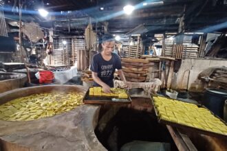 Seorang pekerja sedang menyusun tahu kuning saat proses produksi dilakukan di pabrik tahu di kawasan Ciracas, Jakarta Timur, Kamis (17/10/2024). Foto: Joesvicar Iqbal/ipol.id