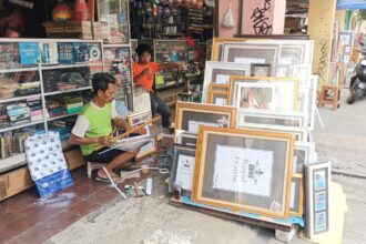 Pedagang bingkai, Kasbari, saat memajang dagangan frame dan foto Presiden Republik Indonesia (RI), Prabowo Subianto dan Wakil Presiden RI, Gibran Rakabuming Raka di depan tokonya di kawasan Jatinegara, Jakarta Timur, Senin (21/10/2024) siang. Foto: Joesvicar Iqbal/ipol.id