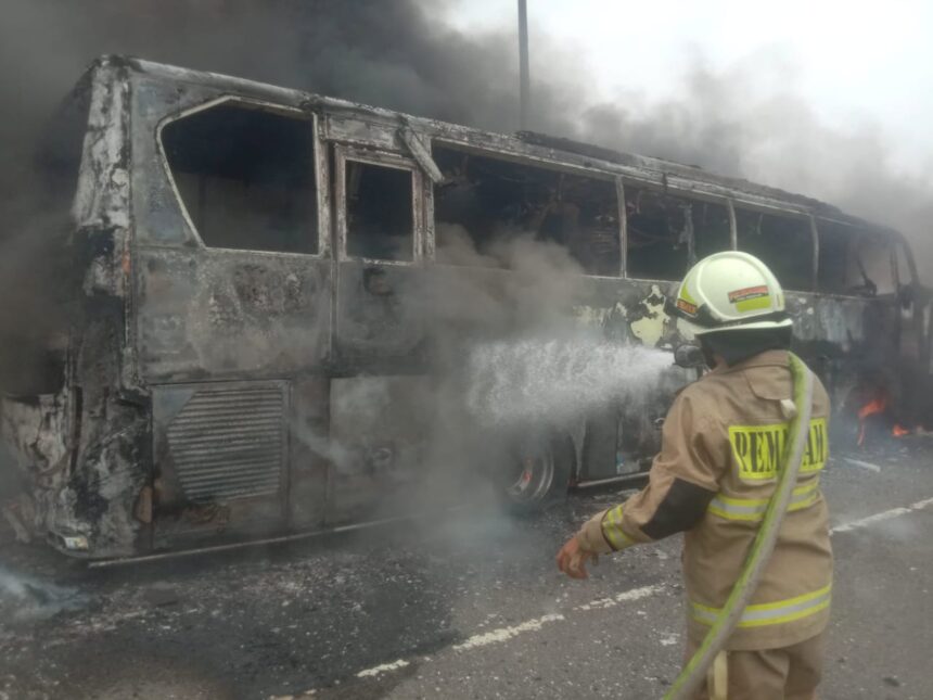 Sejumlah petugas Damkar berupaya memadamkan api yang menghanguskan bus pariwisata (Bersama Putra Trans) bernopol B 7179 VGA di Tol Wiyoto Wiyono KM 03, Cipinang Besar Utara, Jatinegara, Jakarta Timur, Kamis (24/10/2024). Foto: Ist