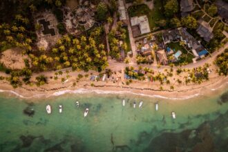 Ilustrasi - Pemandangan indah destinasi wisata lepas pantai dengan penginapan dan sejumlah kapal boats yang terparkir terpantau dari udara. Foto: Freepik