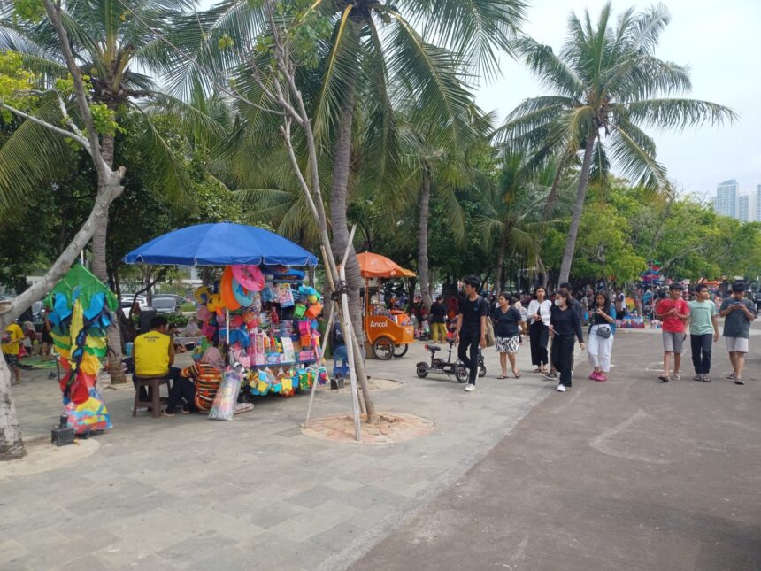 Suasana para pengunjung menikmati pemandangan hingga bermain bersama keluarga di Pantai Ancol di Jakarta Utara. Foto: Joesvicar Iqbal/dok/ipol.id