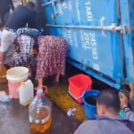 Warga mengambil tumpahan minyak dari truk kontainer yang terguling di Makassar. Foto: Tangkapan layar video warga