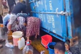 Warga mengambil tumpahan minyak dari truk kontainer yang terguling di Makassar. Foto: Tangkapan layar video warga