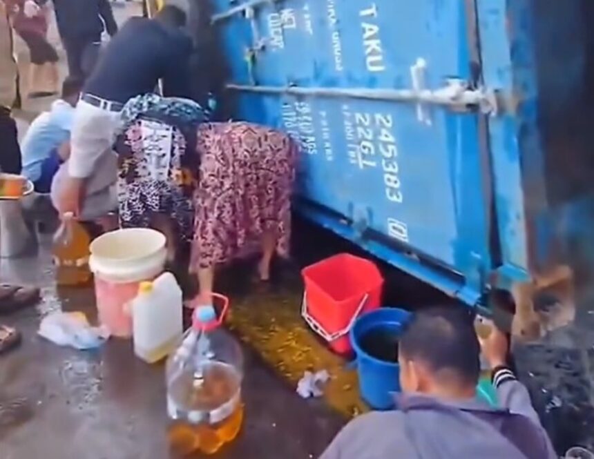 Warga mengambil tumpahan minyak dari truk kontainer yang terguling di Makassar. Foto: Tangkapan layar video warga