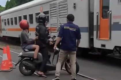 Pengendara motor hampir tertabrak kereta api di Bandung. Foto: X @bacottetangga__