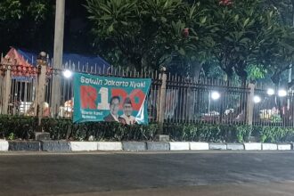 Salah satu alat peraga kampanye salah satu paslon pada Pilkada Jakarta 2024 terbentang di pagar pembatas jalan di Jalan Raya Bogor, Kramat Jati, Jakarta Timur, belum lama ini. Foto: Joesvicar Iqbal/ipol.id